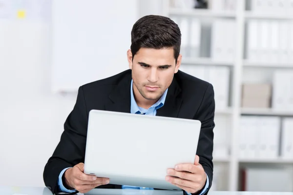 Neugieriger Geschäftsmann mit Laptop — Stockfoto