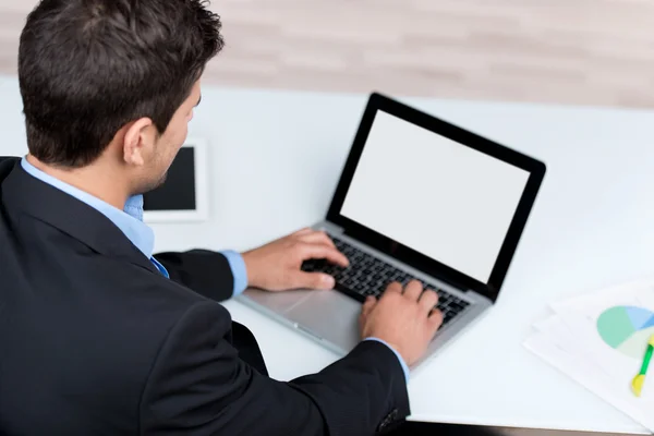 Ung affärsman med laptop på skrivbordet — Stockfoto