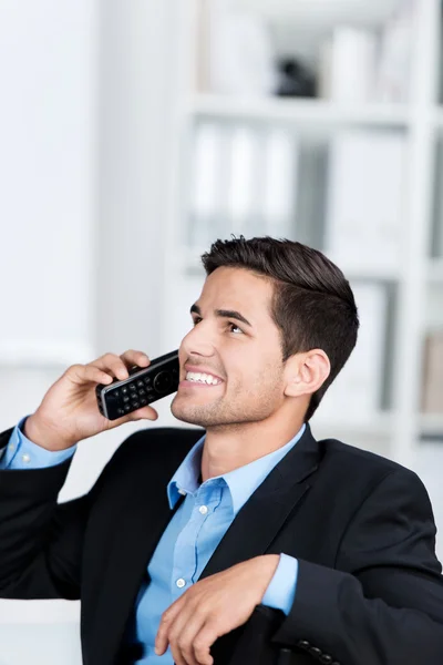 Uomo d'affari utilizzando il telefono cordless, mentre guardando verso l'alto — Foto Stock