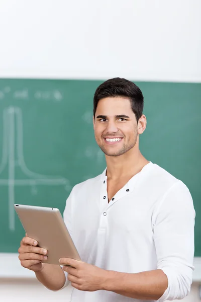 Estudiante masculino sosteniendo tableta digital en el aula —  Fotos de Stock