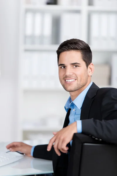 Jeune homme d'affaires assis au bureau — Photo