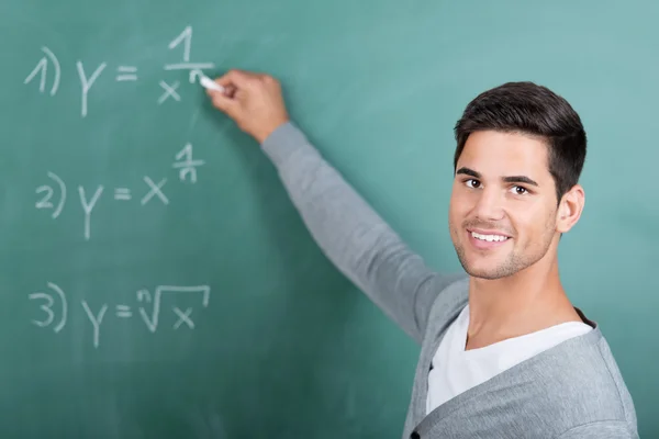 Mannelijke student bedragen op schoolbord op te lossen — Stockfoto