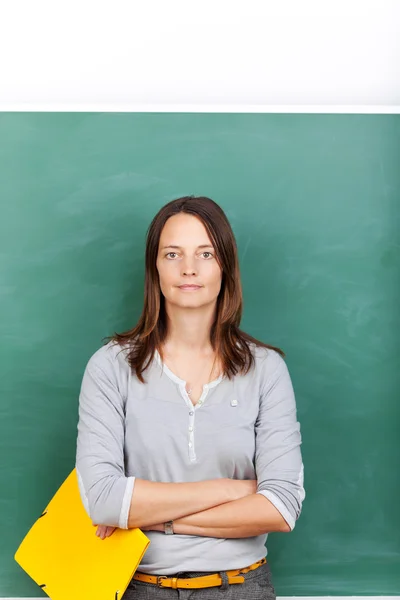 Mid volwassen leraar houden bestand tegen schoolbord — Stockfoto