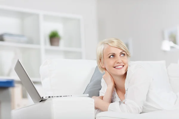 Mulher sorridente com laptop olhando para o lado — Fotografia de Stock