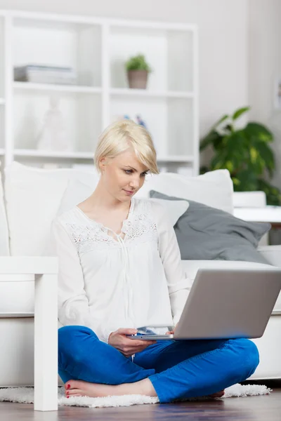 Kvinna på hem plundring på laptop — Stockfoto