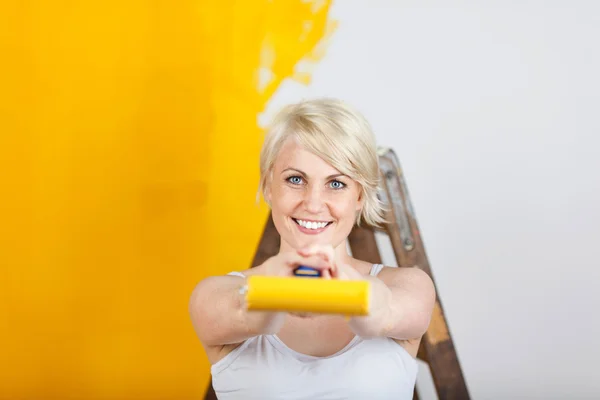 Mujer feliz pintura amarillo — Foto de Stock