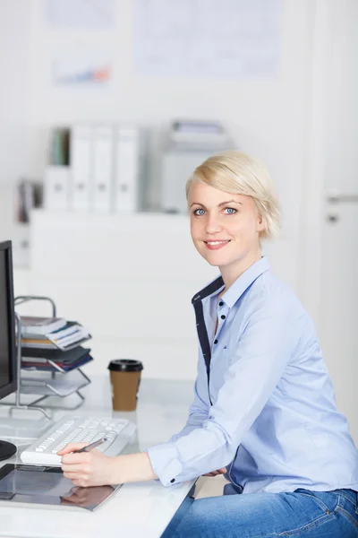Улыбающаяся блондинка-предпринимательница, сидящая в офисе — стоковое фото