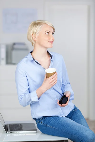 Mujer de negocios con taza de café desechable por ordenador portátil — Foto de Stock