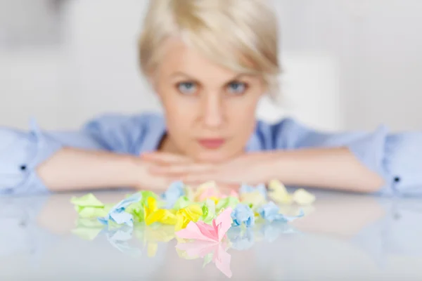 Executivo feminino com bolas de papel enrugadas coloridas na mesa — Fotografia de Stock