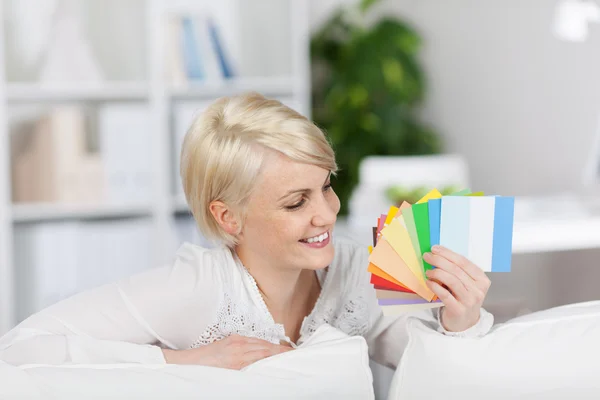 Mujer feliz sosteniendo muestras de color en casa —  Fotos de Stock