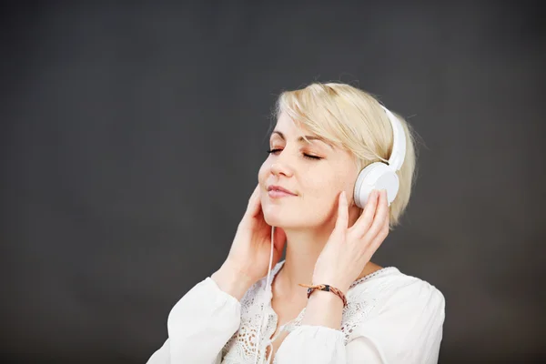 Femme avec écouteurs jouissant de la musique — Photo
