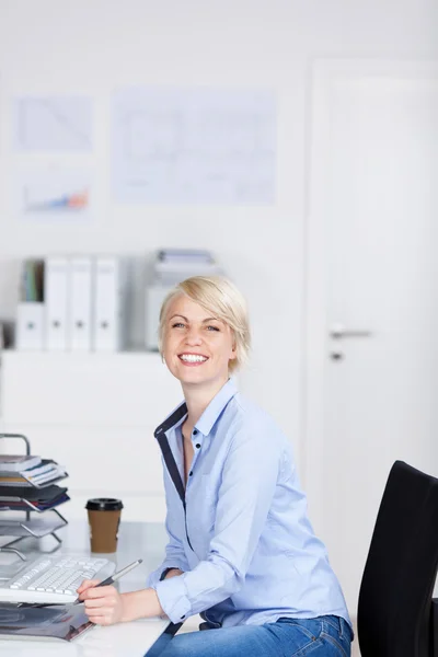 Šťastný podnikatelka, sedí v kanceláři — Stock fotografie