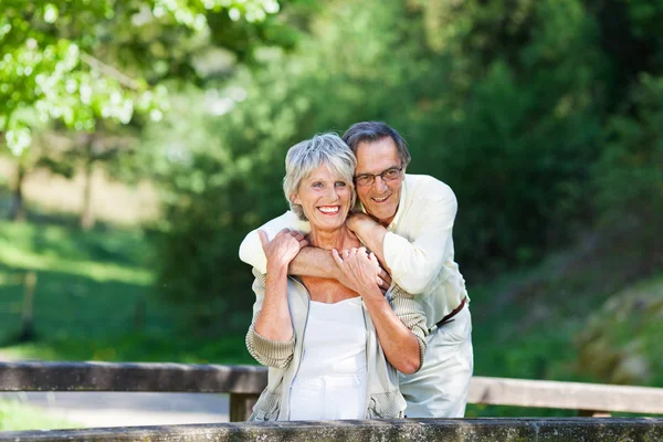 Senior Man Embracing Wife From Behind While Looking Away — Stock Photo, Image