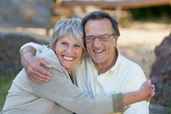 Liefdevolle senior koppel omarmen in park — Stockfoto