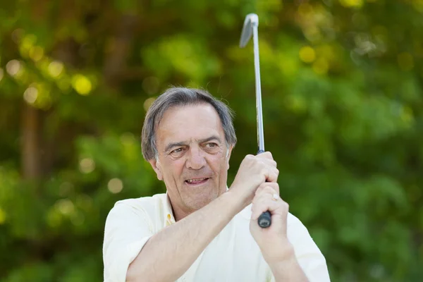 Elderly man with golf stick in action — Stock Photo, Image