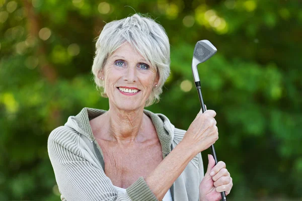 Alte Dame hält Golfschläger in der Hand — Stockfoto