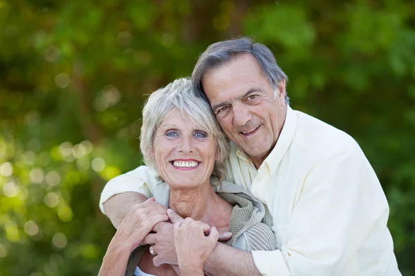 Счастливая старшая пара обнимается и улыбается — стоковое фото