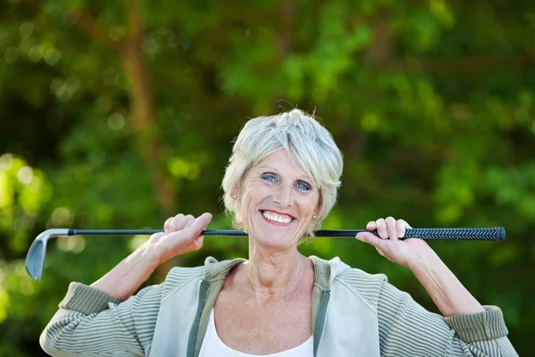 Happy older woman with a golf stick — Stock Photo, Image