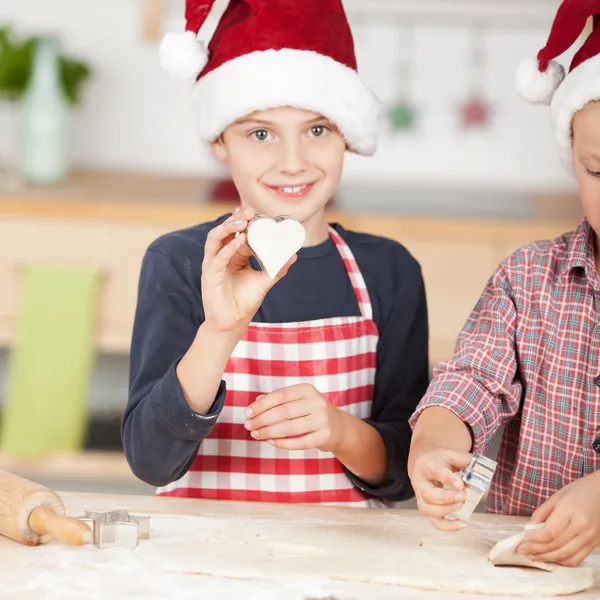 Netter Junge zeigt Lebkuchenherz — Stockfoto