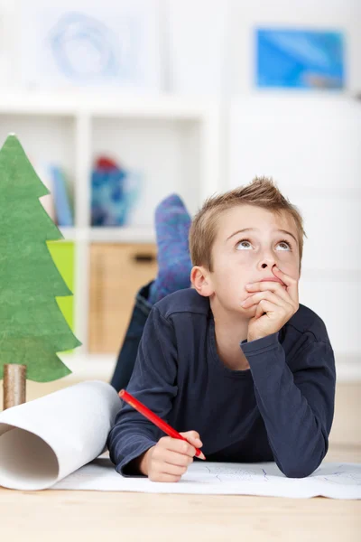 Ung pojke tänkande om önskemål till jul — Stockfoto