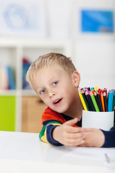 Menino com lápis coloridos na mesa — Fotografia de Stock