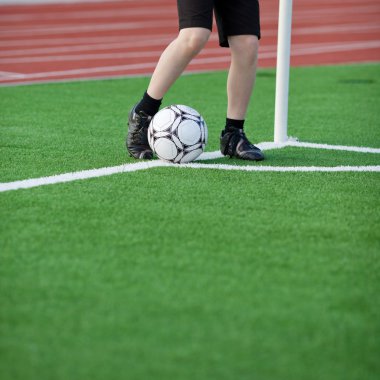 Boy Kicking Soccer Ball At Corner clipart