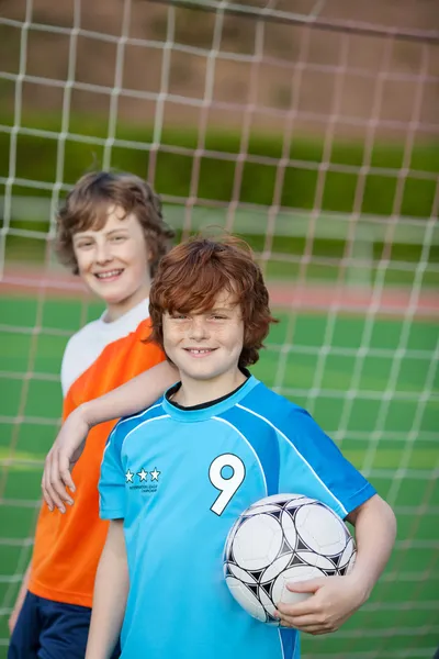 Два молодых игрока перед футбольными воротами — стоковое фото