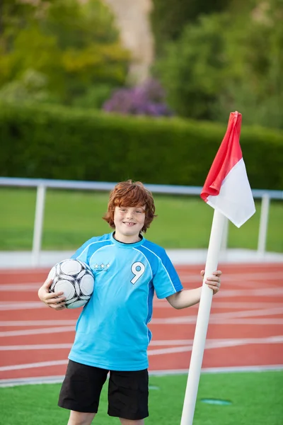 Teenager steht bei Eckball und hält Ball — Stockfoto