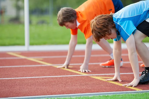 Unga löpare på startposition på travet — Stockfoto