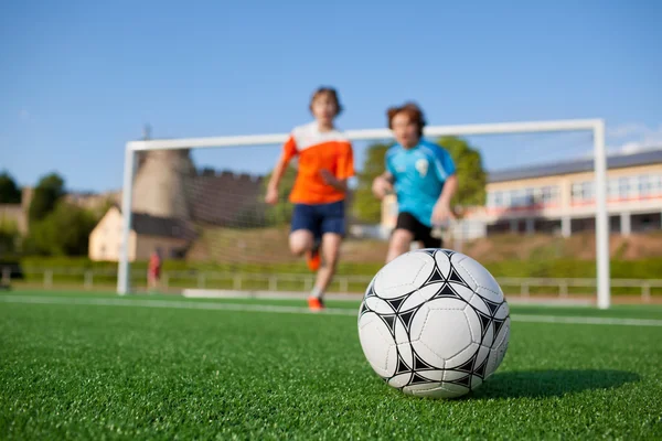 Deux jeunes joueurs de football courent au ballon de football — Photo