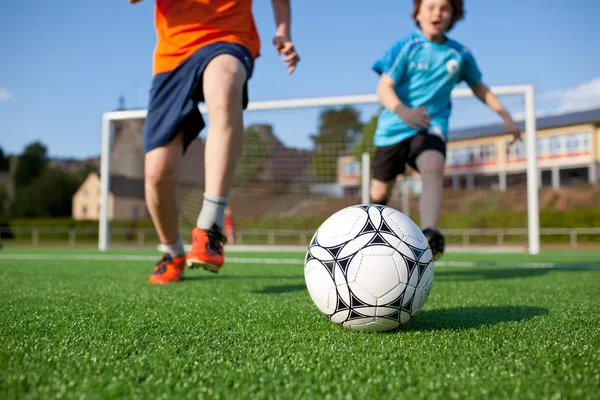 Meninos jogando futebol em campo — Fotografia de Stock