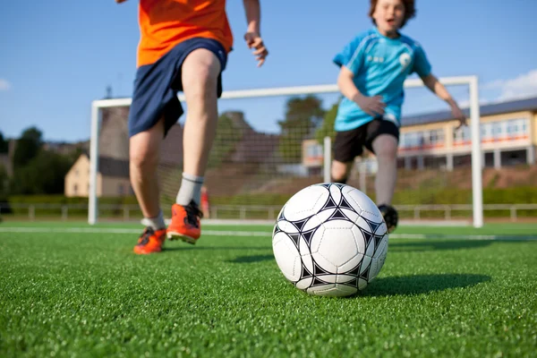 Garçons jouant au football sur le terrain — Photo