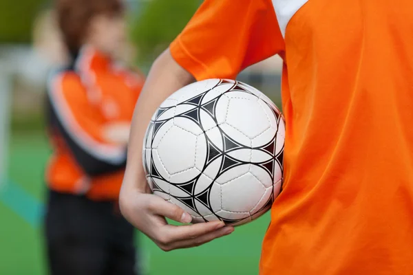 Menino segurando bola de futebol no campo — Fotografia de Stock