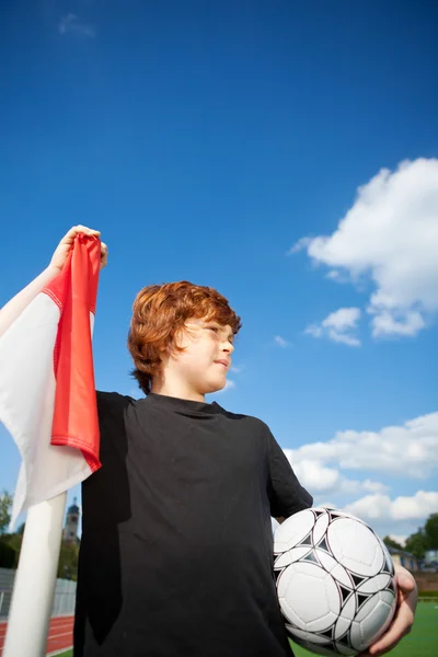 Junge hält Fußball im Stehen an der Eckfahne — Stockfoto