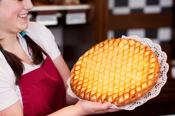 Baker showing off fresh apple tart — Stock Photo, Image