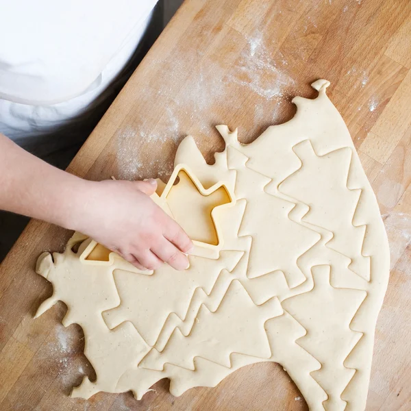 Baker cutting Christmas buscuits in pastry — Stock Photo, Image