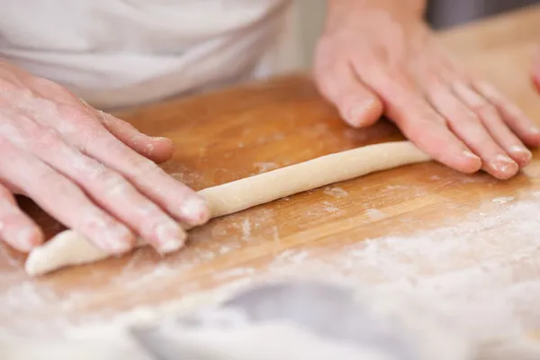 Baker rolling a strip of pastry — Stock Photo, Image