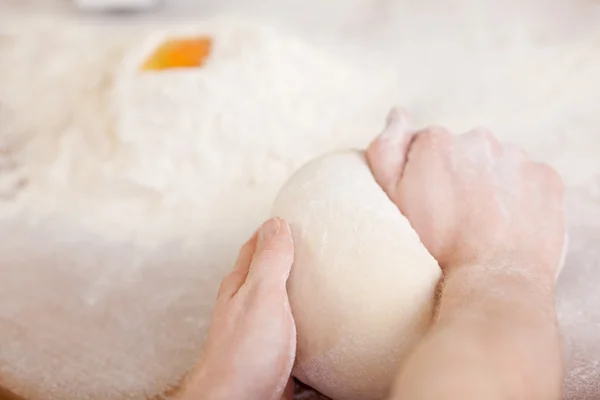 Homme pétrissant la pâte dans une boulangerie — Photo