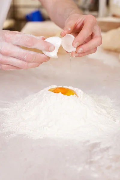 Baker quebrando um ovo — Fotografia de Stock