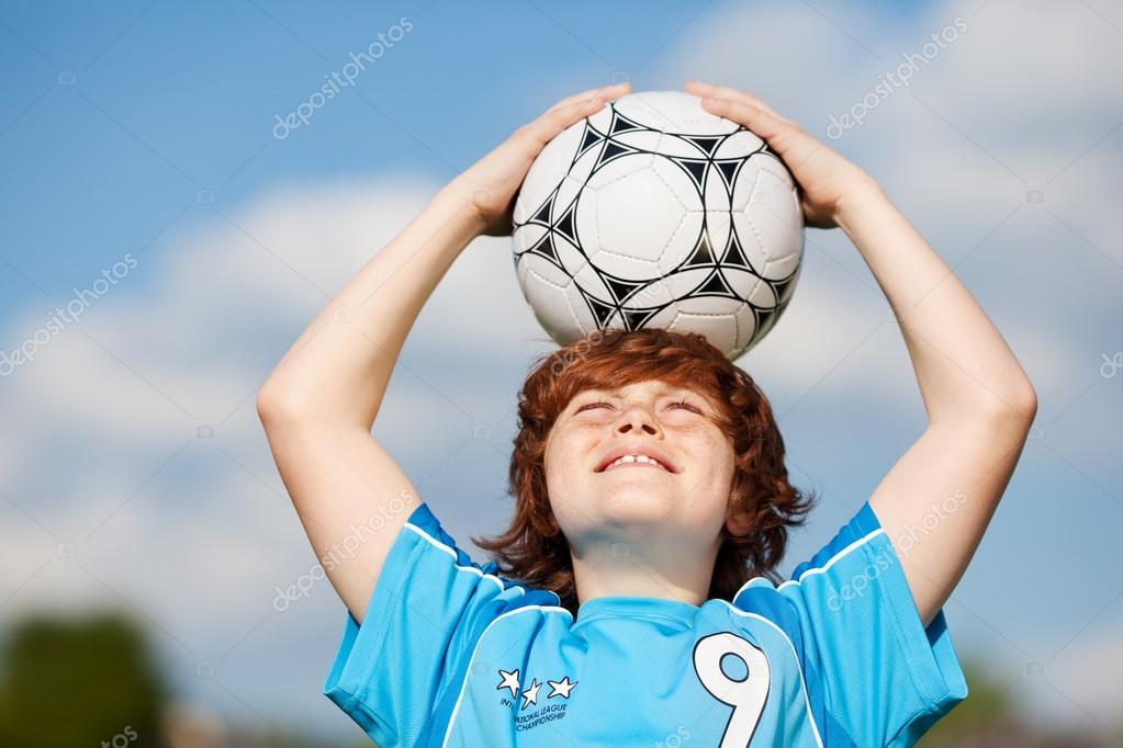 Boy Holding Soccer Ball On Head Against Sky — Stock Photo © racorn 27100805