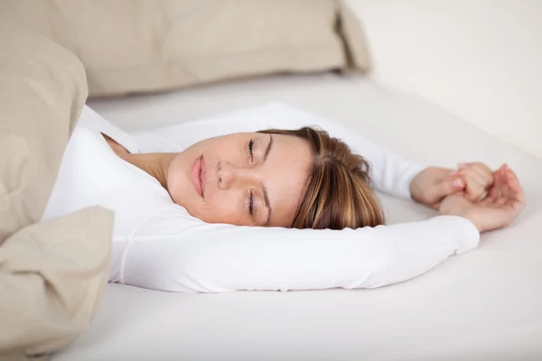 Serena mulher relaxante na cama — Fotografia de Stock