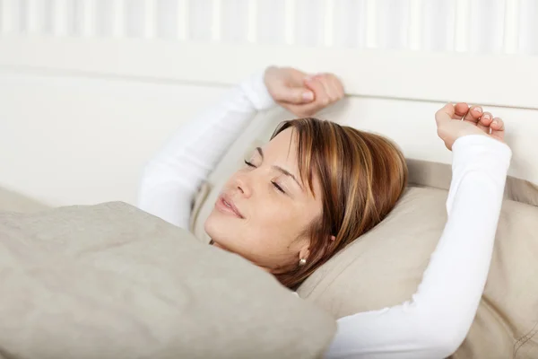 Mujer despertando estirando los brazos — Foto de Stock