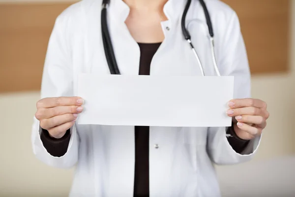 Une femme médecin montrant une feuille blanche vierge — Photo