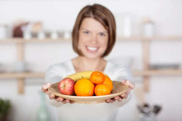 Schöne Frau mit einem Teller voller Früchte — Stockfoto