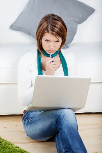 Mulher pensativa estudando seu laptop — Fotografia de Stock
