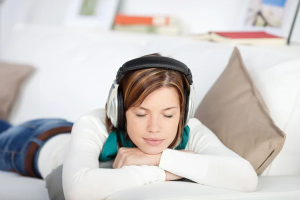 Mujer dichosa disfrutando de la música en sus auriculares —  Fotos de Stock