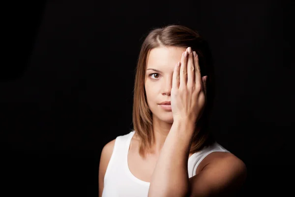 Young female model hiding her left eye Stock Photo