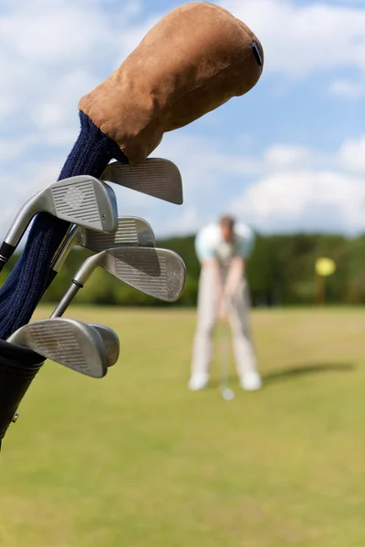 Saco de golfe com golfista no fundo — Fotografia de Stock