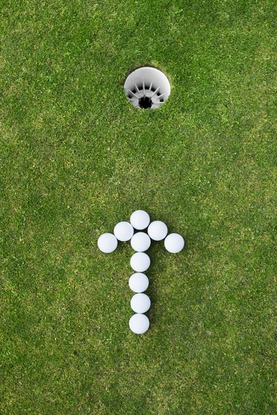 Golfbälle als Pfeilzeichen angeordnet — Stockfoto