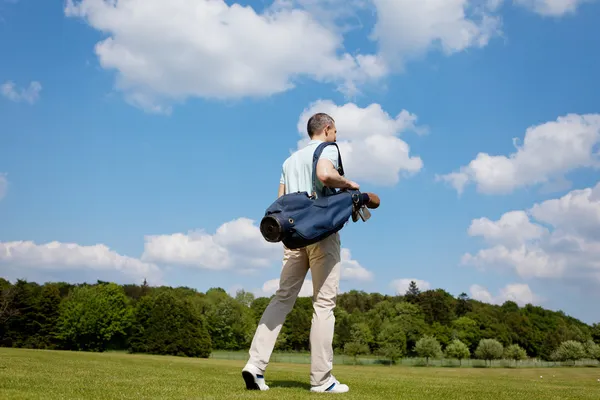 Olgun erkek Golf Sahası üzerinde çanta taşıyor — Stok fotoğraf